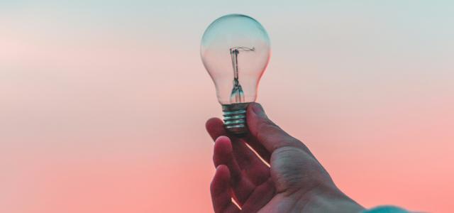 person holding light bulb by Diego PH courtesy of Unsplash.